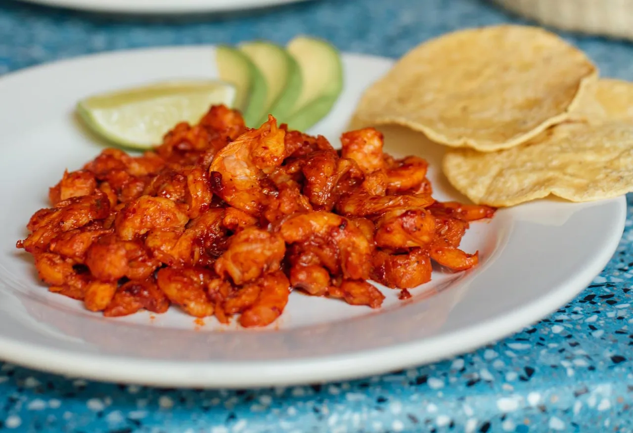Shrimp in red chile with tostadas and avocado.