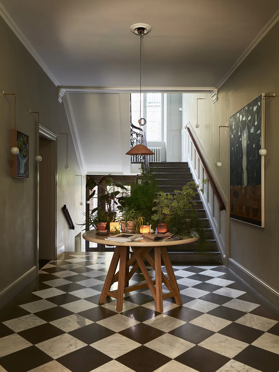The entrance hall, with a chequered floor and stairs.